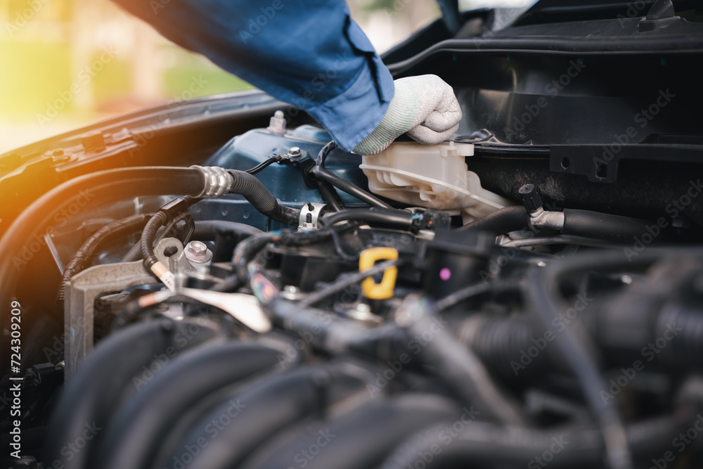 Check auto car coolant level, repair or maintenance. Men hand to open cap of tank or reservoir for filling liquid cooled engine with water, cooling system. Professional mechanic checking car engine. Check auto car coolant level, repair or maintenance. Men hand to open cap of tank or reservoir for filling liquid cooled engine with water, cooling system. Professional mechanic checking car engine.