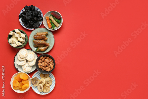 Plates with different Eastern sweets for Ramadan on red background