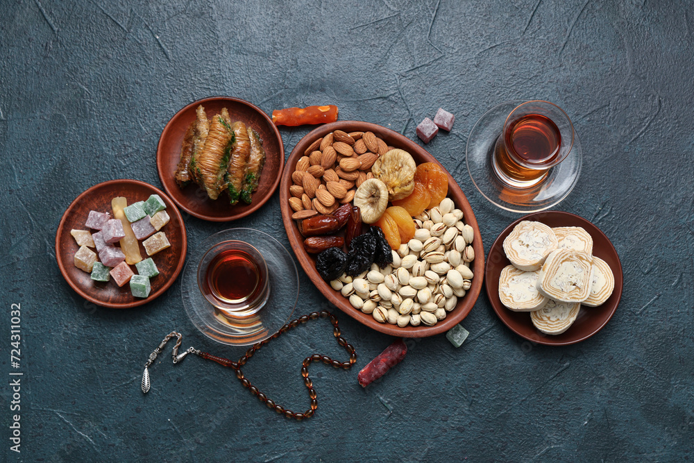 Composition with different Eastern sweets and tea for Ramadan on dark color background Composition with different Eastern sweets and tea for Ramadan on dark color background