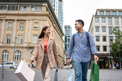 Asian young man and woman shopping goods outdoors in department store.  photo