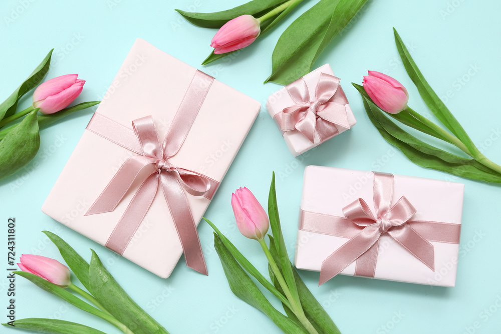Gift boxes and beautiful tulips on blue background. International Women's Day Gift boxes and beautiful tulips on blue background. International Women's Day