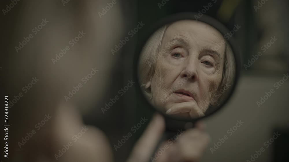 Sad Elderly Woman Watching Herself in Mirror Thinking About the Past Sad Elderly Woman Watching Herself in Mirror Thinking About the Past