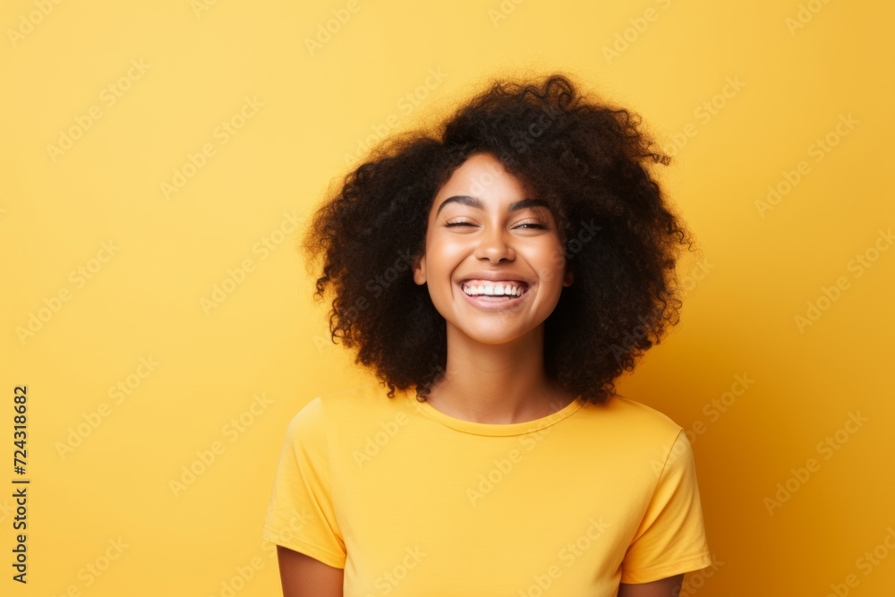 Happy african american young woman in yellow t-shirt on yellow background Happy african american young woman in yellow t-shirt on yellow background