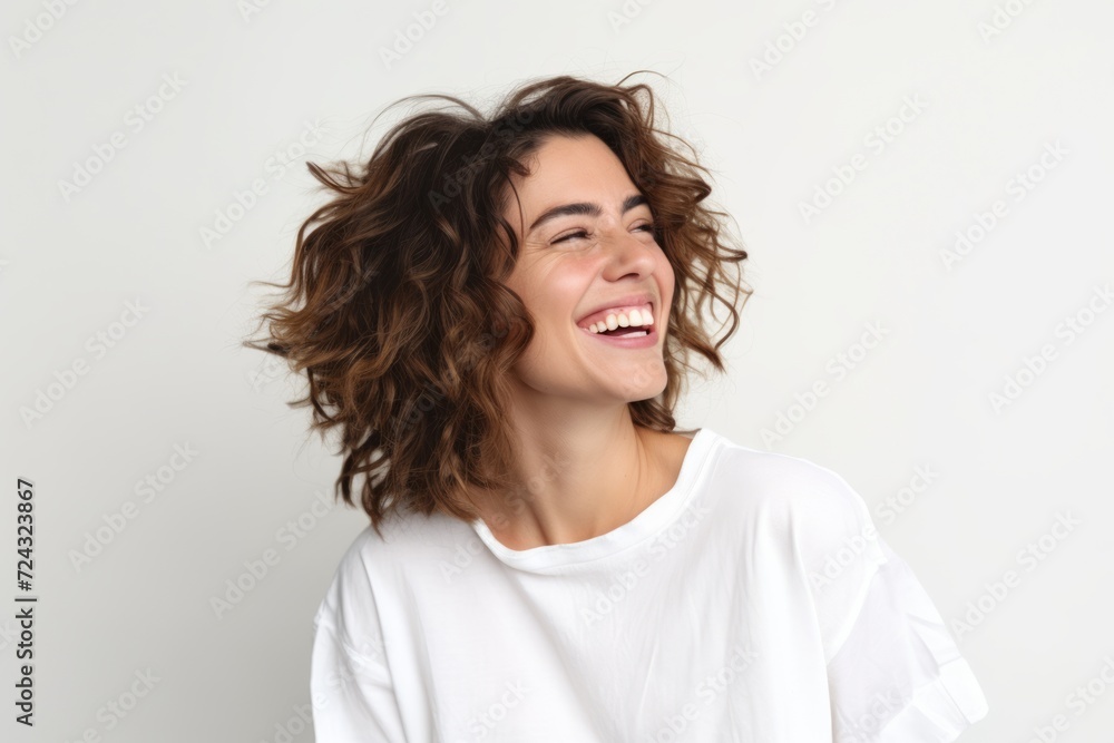 Portrait of a beautiful young woman with curly hair laughing against white background Portrait of a beautiful young woman with curly hair laughing against white background