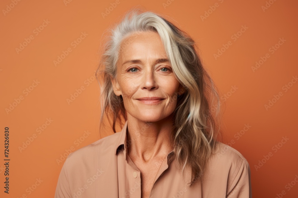 Portrait of smiling senior woman looking at camera isolated on orange background Portrait of smiling senior woman looking at camera isolated on orange background