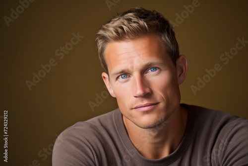 Portrait of a handsome young man over brown background. Men's beauty, fashion.