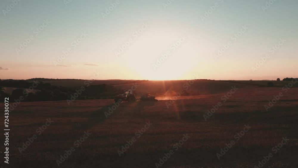 a tractor pulling a planter at sunset a tractor pulling a planter at sunset