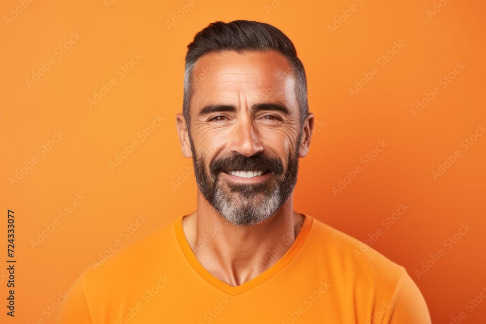 Portrait of happy mature man in orange t-shirt on orange background Portrait of happy mature man in orange t-shirt on orange background