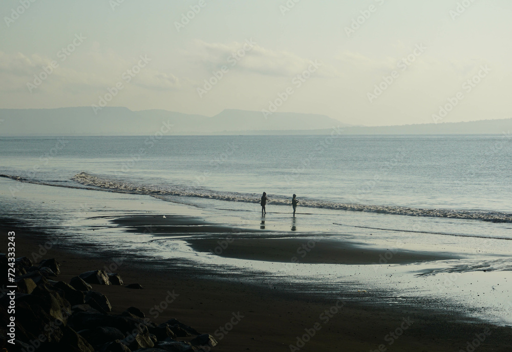 Two people playing on the beach.