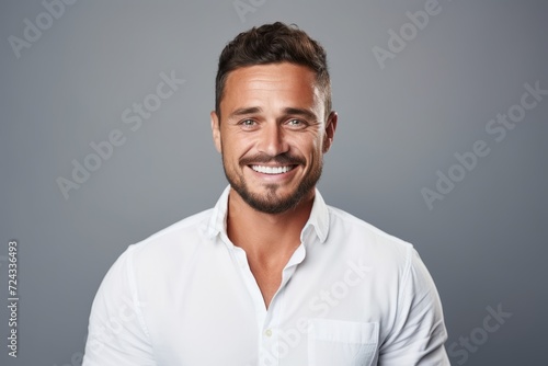 Fototapete Handsome young man in white shirt smiling and looking at camera while standing a