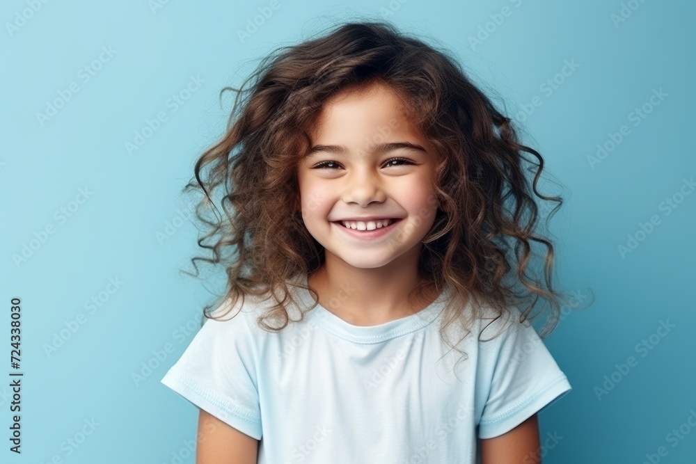 Portrait of a smiling little girl with curly hair on blue background Portrait of a smiling little girl with curly hair on blue background