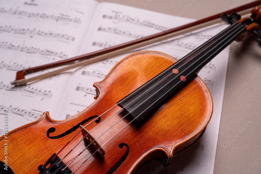 Fototapeta premium Halbe Geige mit Bogen liegt auf Notenblatt, Studioaufnahme, Deutschland