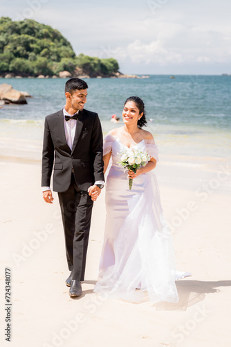 Bride and groom on the beach, walking
