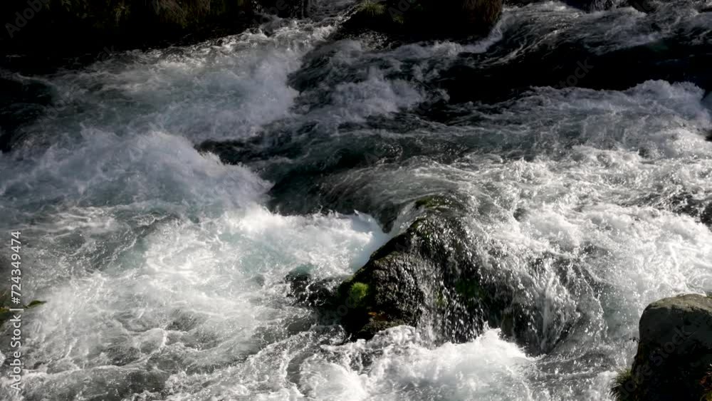 Water flowing through stones, in slow motion. Location the Daiya River in Nikko, Japan, where the gentle flow of water harmonizes with the natural beauty of the surroundings. Water flowing through stones, in slow motion. Location the Daiya River in Nikko, Japan, where the gentle flow of water harmonizes with the natural beauty of the surroundings.