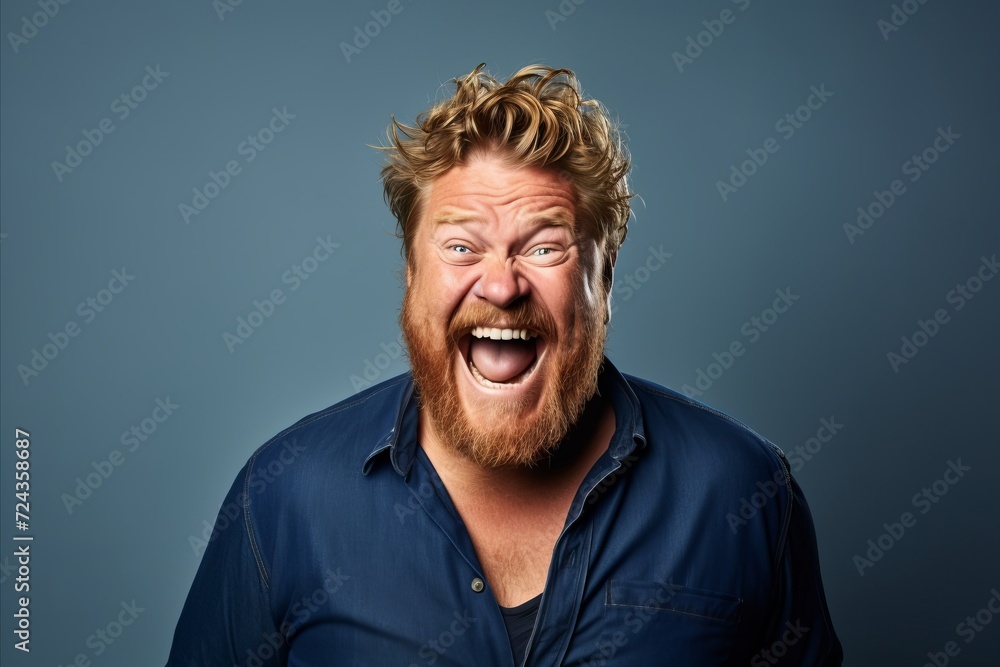 Portrait of a funny man with red hair and beard over blue background