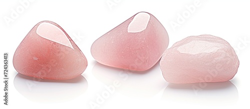 Three tumbled rose quartz stones. Semi-precious rose quartz crystals are a love talisman photo