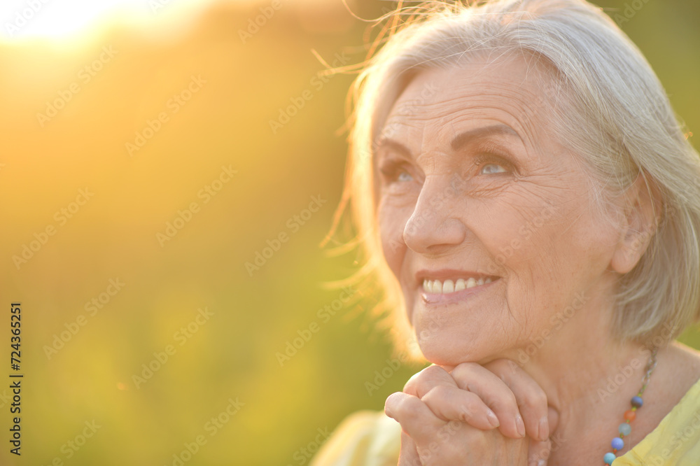 portrait of a happy senior woman in park portrait of a happy senior woman in park