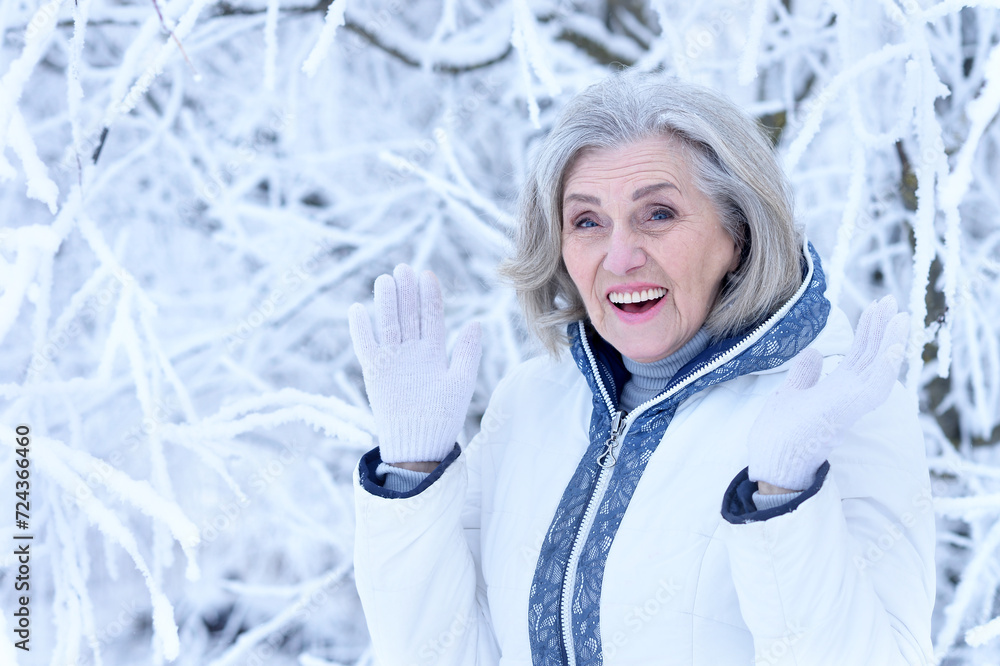 Happy old woman in a fur coat in the winter. 