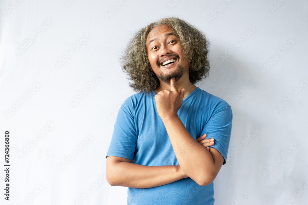 handsome Asian curly man posing with hand touching chin on isolated gray background handsome Asian curly man posing with hand touching chin on isolated gray background