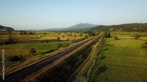 Train move on railway wonderful moment cinematic perspective scenic landscape of Hyrcanian forest mountain view panoramic green meadow rice paddy farm land field summer agriculture iran gilan travel photo