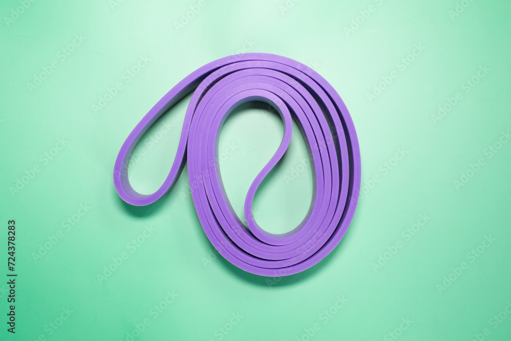 The concept of sports, fitness and a healthy lifestyle. Multicolored fitness rubber bands on a green background. Copy space . The concept of sports, fitness and a healthy lifestyle. Multicolored fitness rubber bands on a green background. Copy space .
