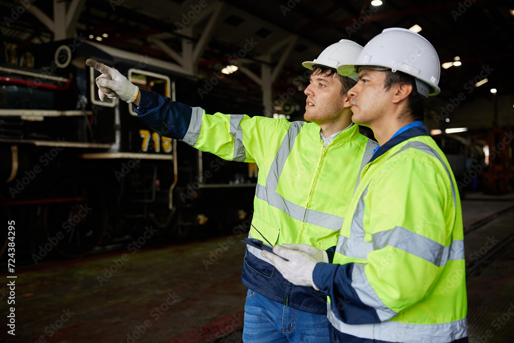 engineers or workers working on tablet and checking construction train at station engineers or workers working on tablet and checking construction train at station