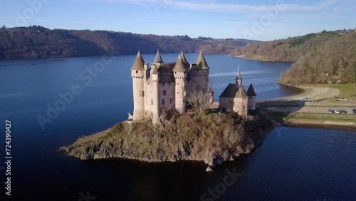 drone shot around chateau de val, french castle on the shore of the artificial lake of bort les les orgues on a sunny day during winter, Cantal departement, auvergne rhone alpes region, france photo