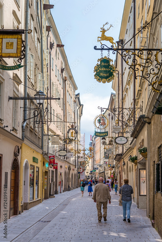 Obraz premium Salzburg, Austria - May 6, 2018: Famous historical street Getreidegasse with multiple advertising signs