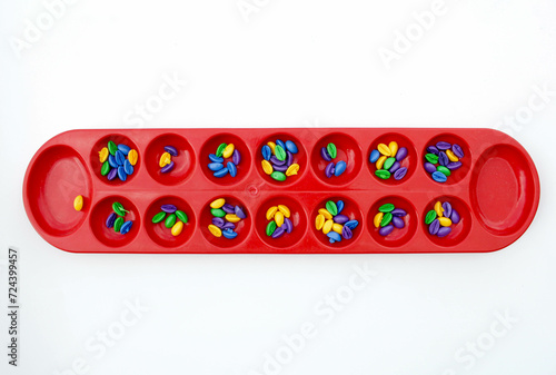 Dakon or Congklak is traditional Indonesian game. Congklak is played by two people facing each other using a board made of wood or plastic. Each small hole is filled with 5-7 seed.