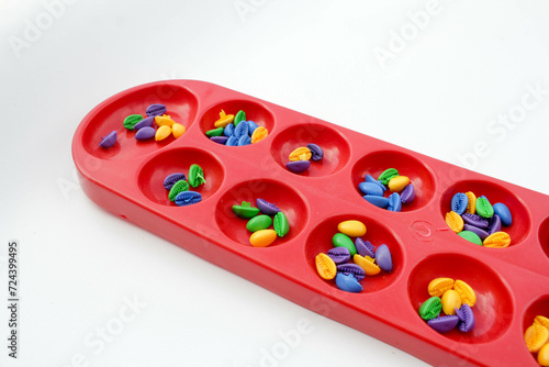 Dakon or Congklak is traditional Indonesian game. Congklak is played by two people facing each other using a board made of wood or plastic. Each small hole is filled with 5-7 seed.