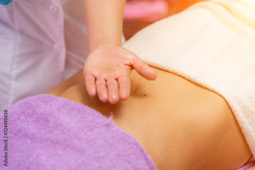 Top view of hands massaging female abdomen.Therapist applying pressure on belly. Woman receiving massage at spa salon Top view of hands massaging female abdomen.Therapist applying pressure on belly. Woman receiving massage at spa salon