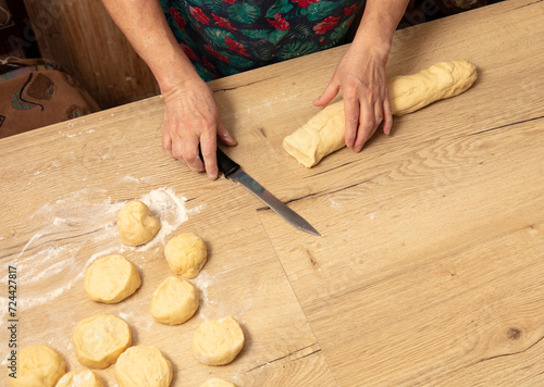 A woman cuts dough with a knife