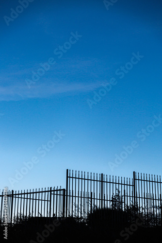 Silhouette of metal fence and empty blue sky on sunse