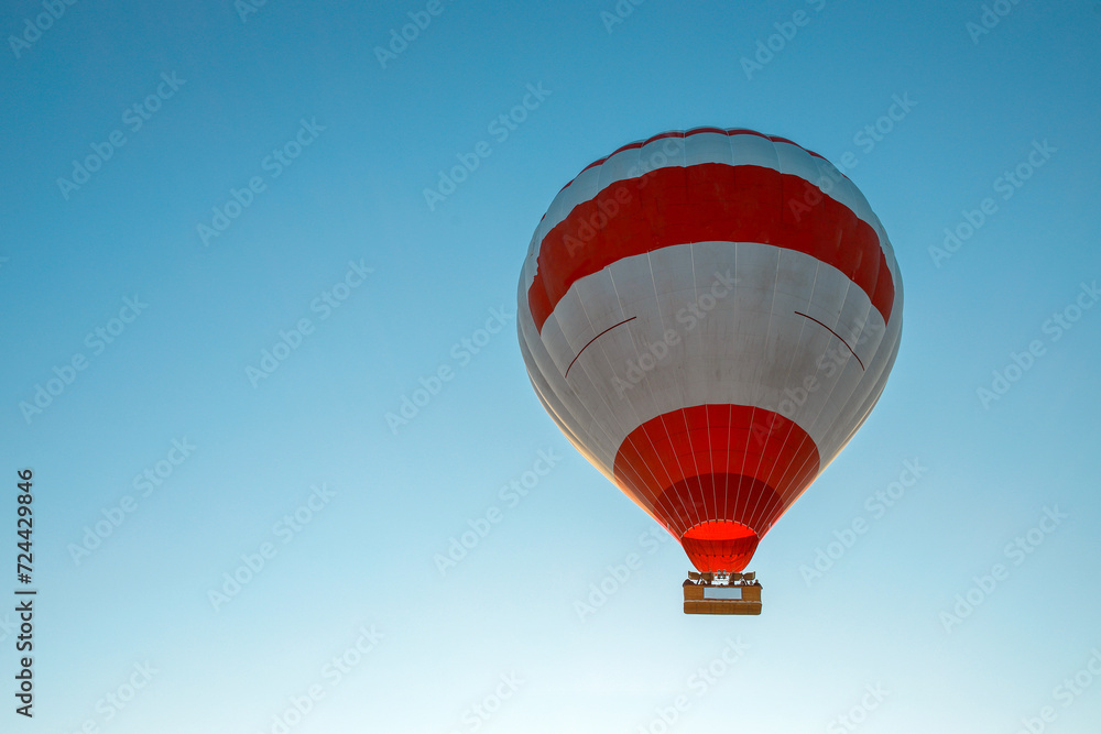 Fototapeta premium Hot air balloon flying against the blue cloudless sky