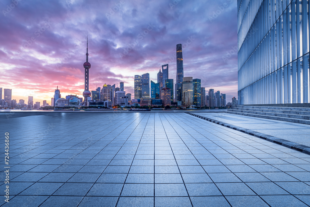Empty square floor and glass wall with modern buildings scenery at sunrise in Shanghai