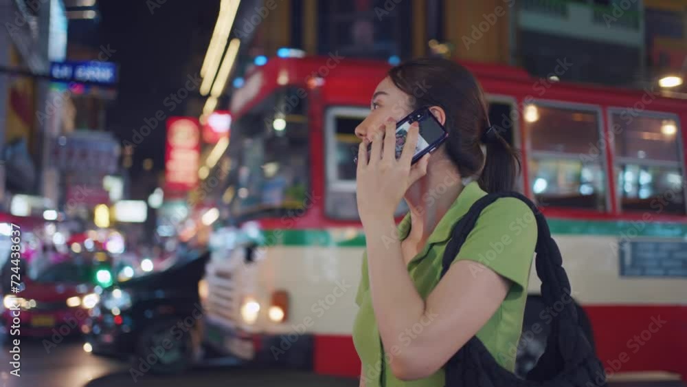 Asian attractive woman backpacker talking on phone while walk in city. Asian attractive woman backpacker talking on phone while walk in city.