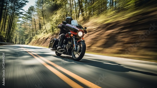 Motorcycle rider in helmet and leather jacket racing on asphalt road with blurred background © Ameer