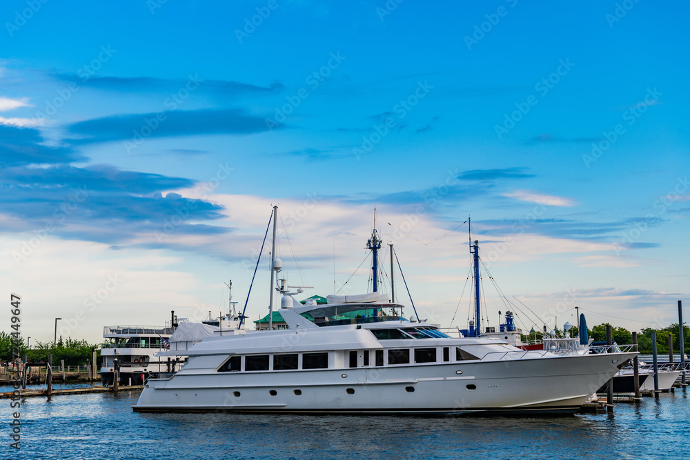 Yacht vacation in summer. A luxury private motor yacht in sea harbor. Yacht in navigation. Private white luxury anchored off the beach. Summer vacation. Summertime yachting. Coastline