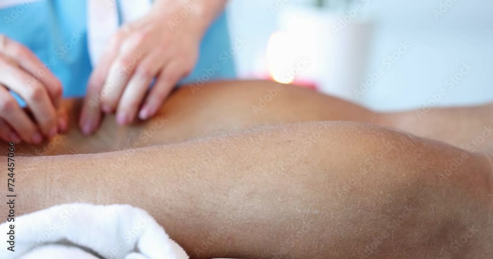 Masseuse doing sports massage of male lower leg. Professional therapist with strong arms performing foot and lower leg massage closeup Masseuse doing sports massage of male lower leg. Professional therapist with strong arms performing foot and lower leg massage closeup
