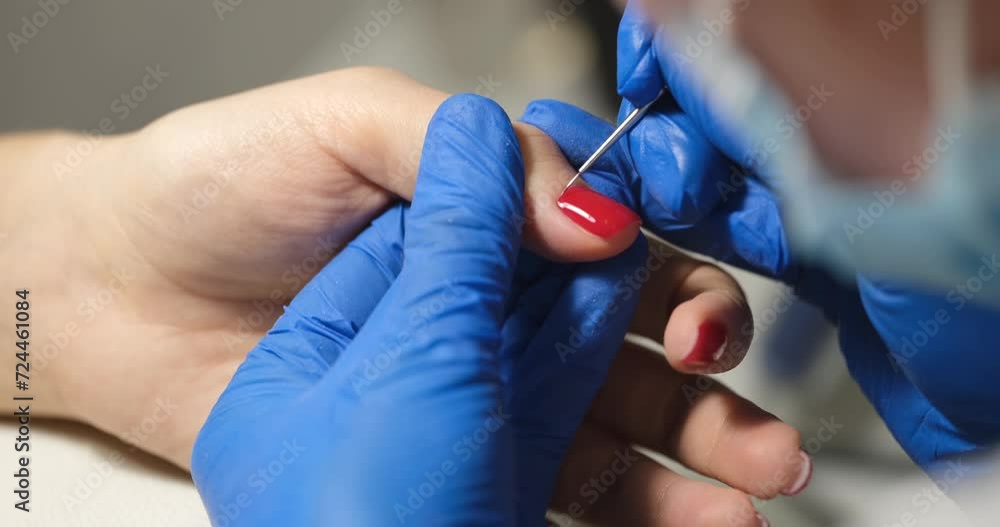 Manicurist covers client nails with red nail polish. Beauty salon and manicure pedicure concept Manicurist covers client nails with red nail polish. Beauty salon and manicure pedicure concept