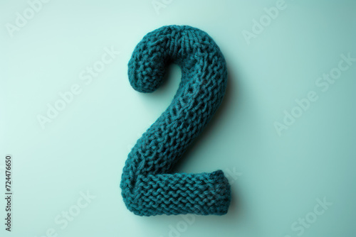  Crocheted number 7 with rich teal wool, showcasing a sleek, modern look on a soft beige background