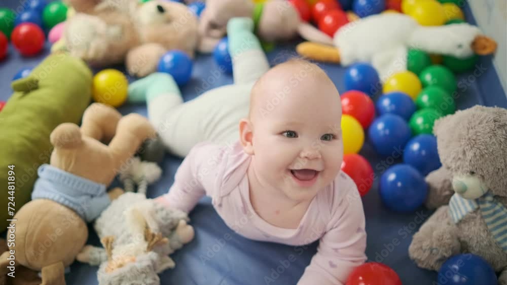 Cute baby girl playing with colorful toys in the nursery at home Cute baby girl playing with colorful toys in the nursery at home
