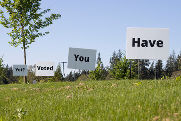 Low angle view of "Have You Voted Yet" lawn signs with clear blue sky in the background. Election Day concept.