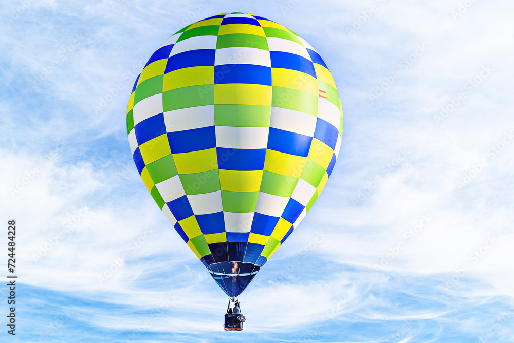 Naklejka premium Colorful hot air balloon flying over blue sky with white clouds