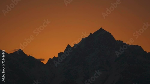 Silhouette shot of snow covered Kinnaur Kailash mountain during the sunrise in winter as seen from Kalpa in Kinnaur, Himachal Pradesh, India. View of Holy Kinnaur Kailash mountain range in morning.	 photo