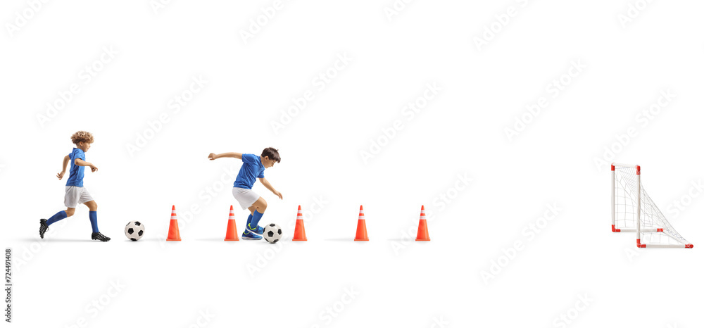 Boys training football with obstacle cones in front of a goal
