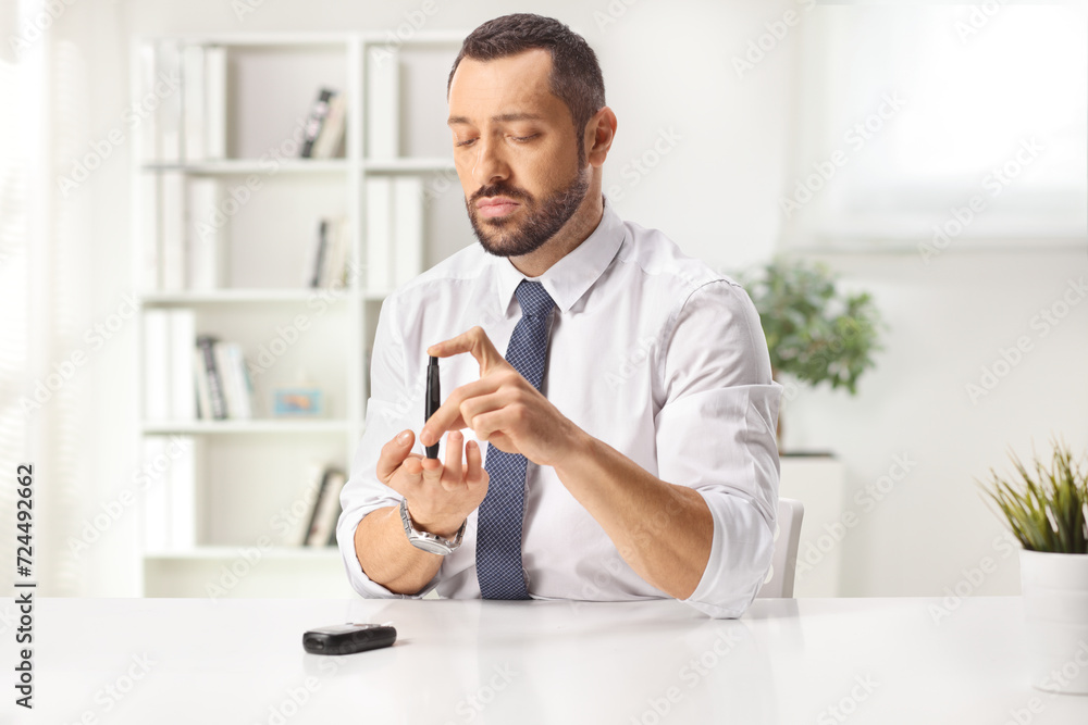 Man pricking finger and checking blood sugar level Man pricking finger and checking blood sugar level