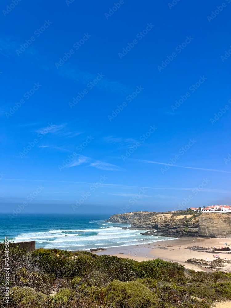 Fototapeta premium Rocky ocean coast, ocean bay with rocky coast and sand beach, blue sky, no people