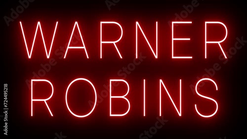 Flickering red retro style neon sign glowing against a black background for WARNER ROBINS photo