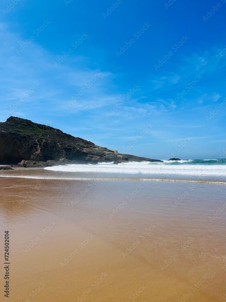 Rocky ocean coast, ocean bay with rocky coast and sand beach, blue sky, no people